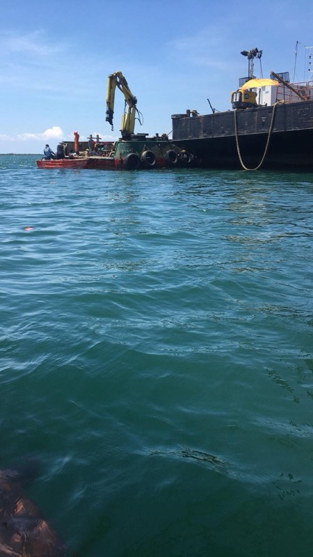 Barge with excavator on water